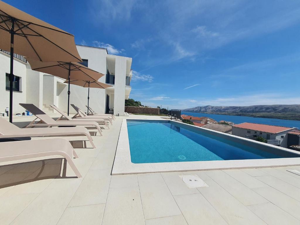 a swimming pool with chairs and an umbrella on a building at Holiday Villa Zubovici with private pool in Zubovići