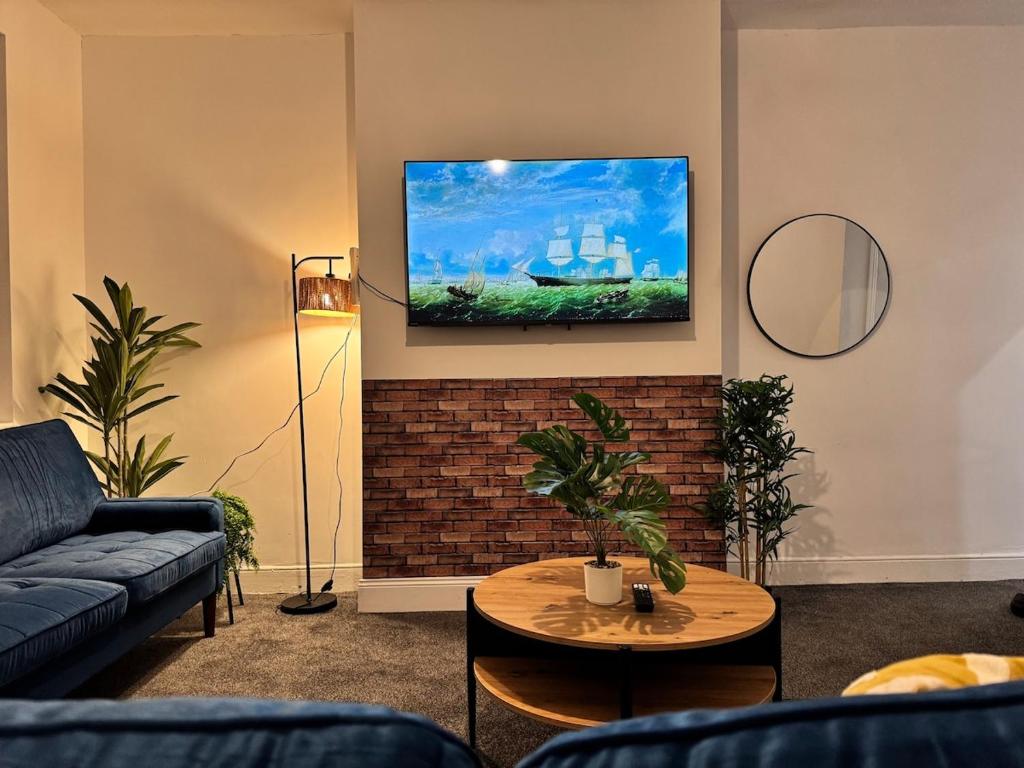 a living room with a couch and a tv on a wall at 3 BD Luxury Stay For Contractors & Families in Newcastle upon Tyne