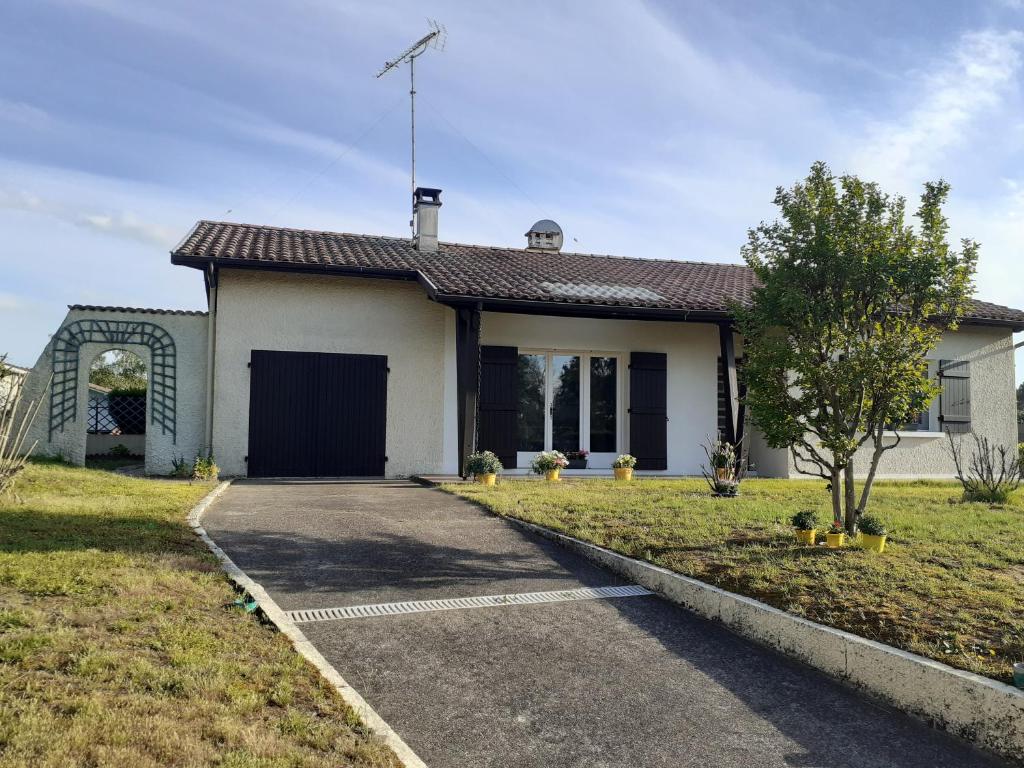 une petite maison blanche avec une allée. dans l'établissement La Maison LEON, à Ychoux