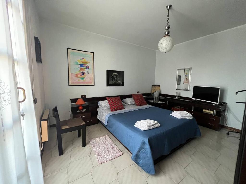 a bedroom with a blue bed and a desk at Case vacanze Efisio e Vilma in Santa Giusta