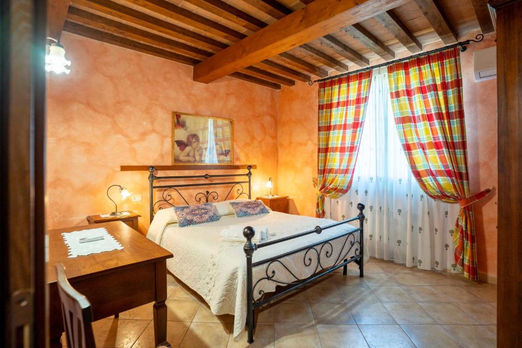 sypialnia z łóżkiem, biurkiem i oknem w obiekcie Agriturismo Corte degli Angeli w mieście Marina di Grosseto