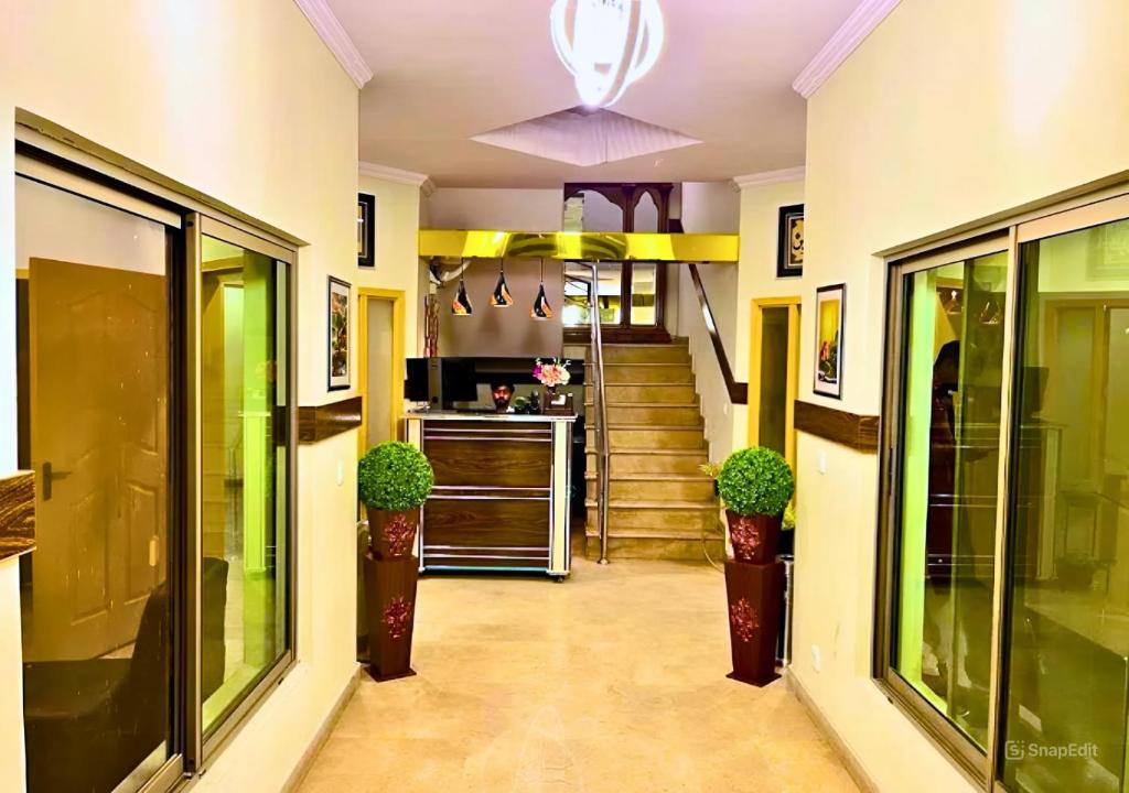 a hallway with stairs and potted plants in a building at Doves Inn Hotel kalma Chowk in Lahore