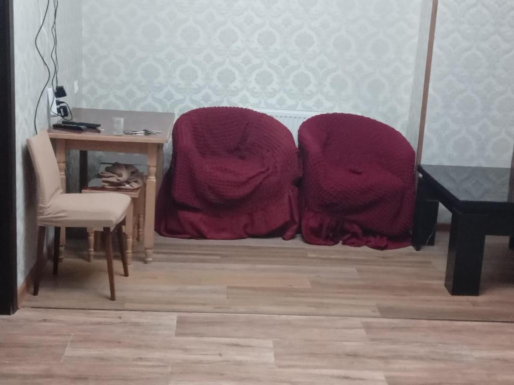 deux couvertures sur le sol dans une pièce avec une table dans l'établissement A cozy corner im Saburtalo 3, à Itʼkhvisi
