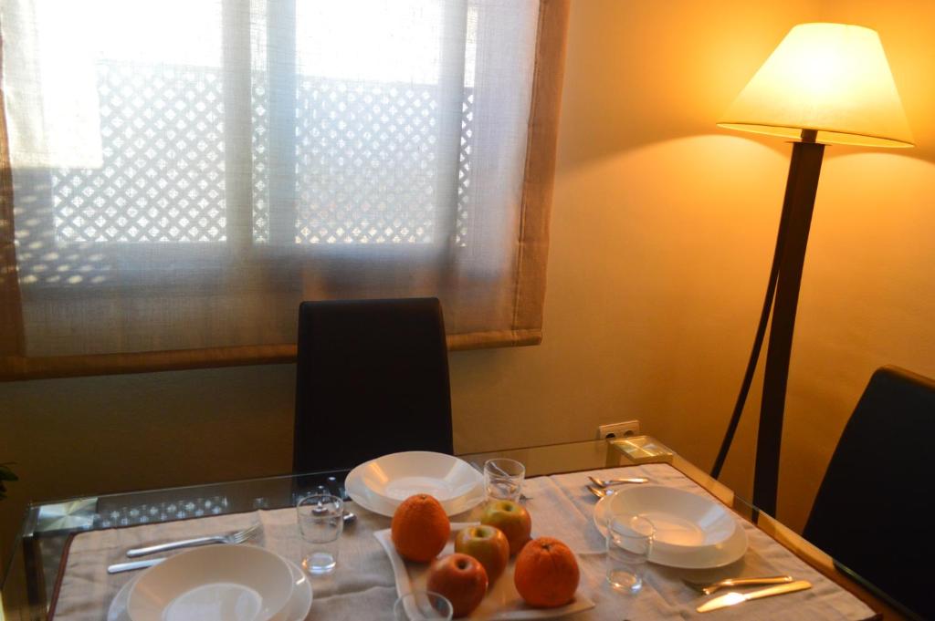 una mesa con platos y naranjas encima en Apartamento La Ronda, en Jerez de la Frontera