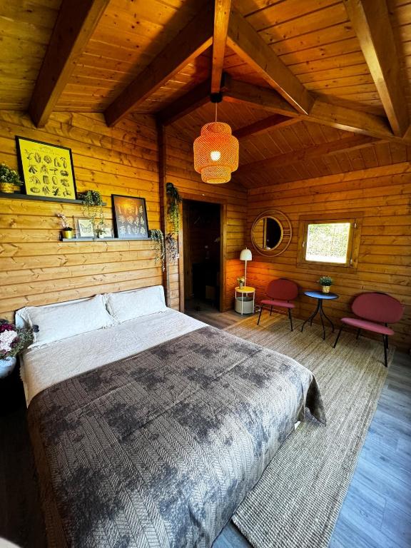 a bedroom with a large bed in a wooden room at The Bungalow - Quinta da BellaVista in Almoster