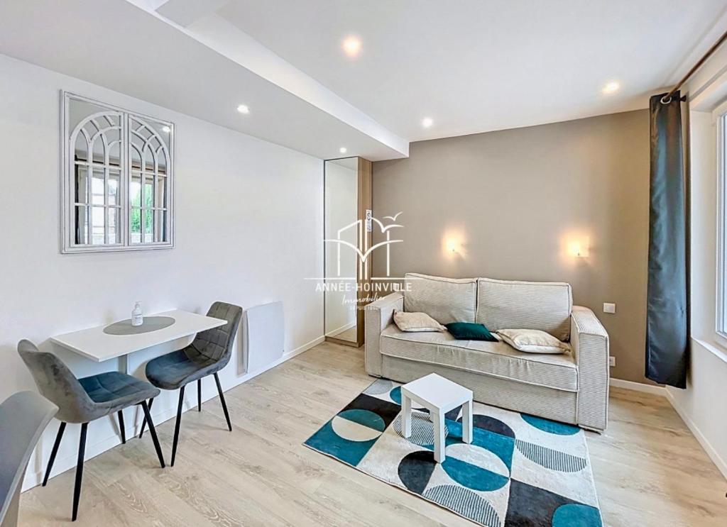 un salon avec un canapé et une table dans l'établissement Hyper centre! Magnifique studio à proximité directe de la gare et place morny, à Deauville