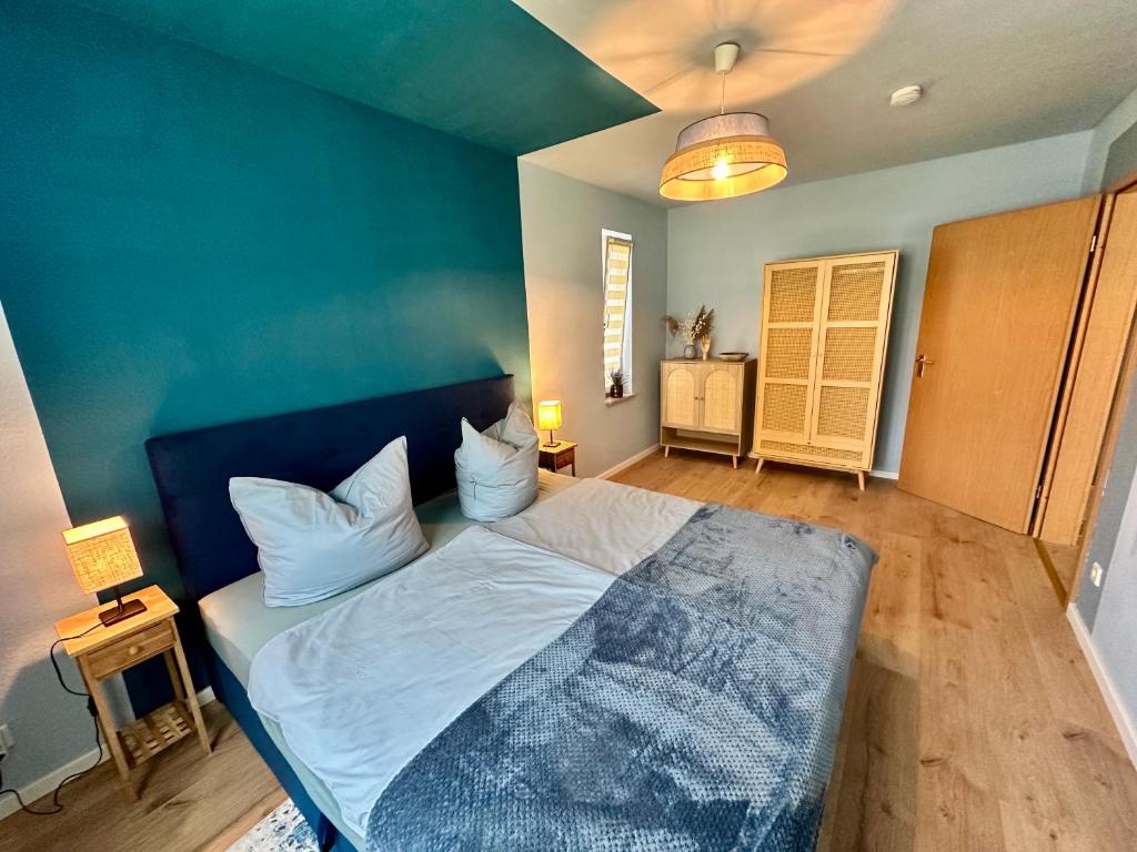a bedroom with a bed with a blue wall at Barrierefrei und Hunde willkommen Hohe Gäste in Naumburg