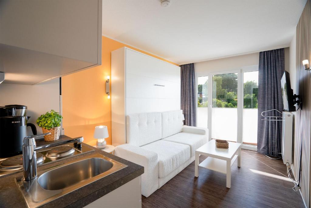 TV a/nebo společenská místnost v ubytování Das Solaris 18 Beach Apartment mit Gemeinschaftssauna und Grillplatz