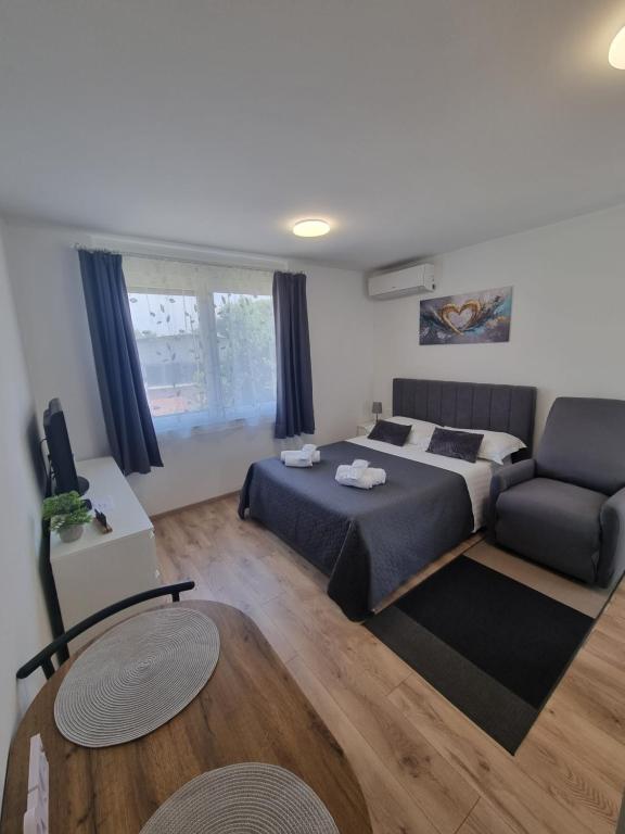 a bedroom with a bed and a couch at Studio Apartment Petra Umag in Umag