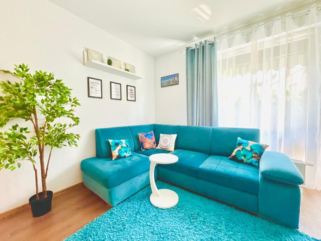 un divano blu in un soggiorno con un tavolo di Bronowice Residence Blue - Homey Apartment with Garden and Parking a Cracovia