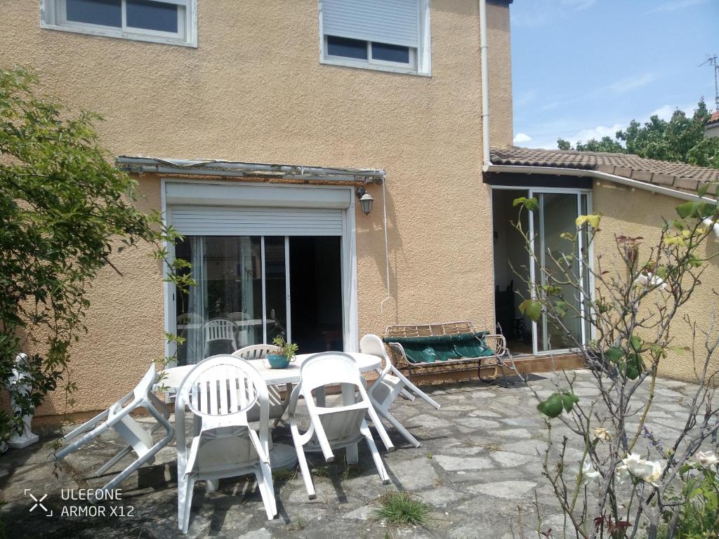 un patio avec des chaises et une table devant une maison dans l'établissement Maison St Jean de Védas centre, à Saint-Jean-de-Védas