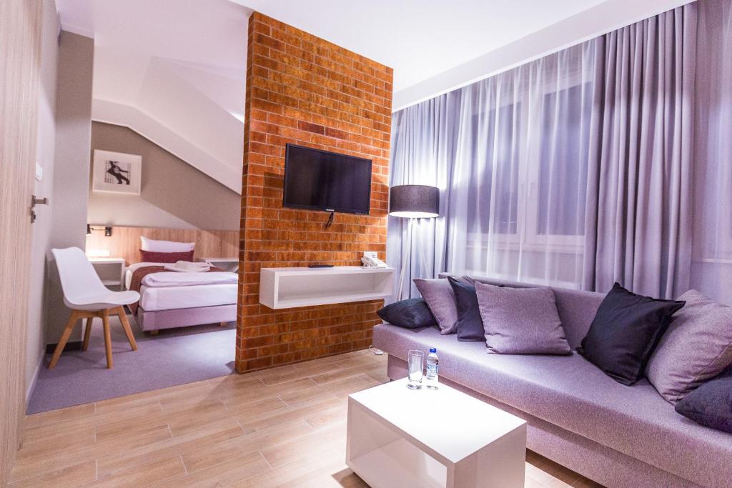 - un salon avec un canapé et une table dans l'établissement Hotel Falcon, à Rzeszów