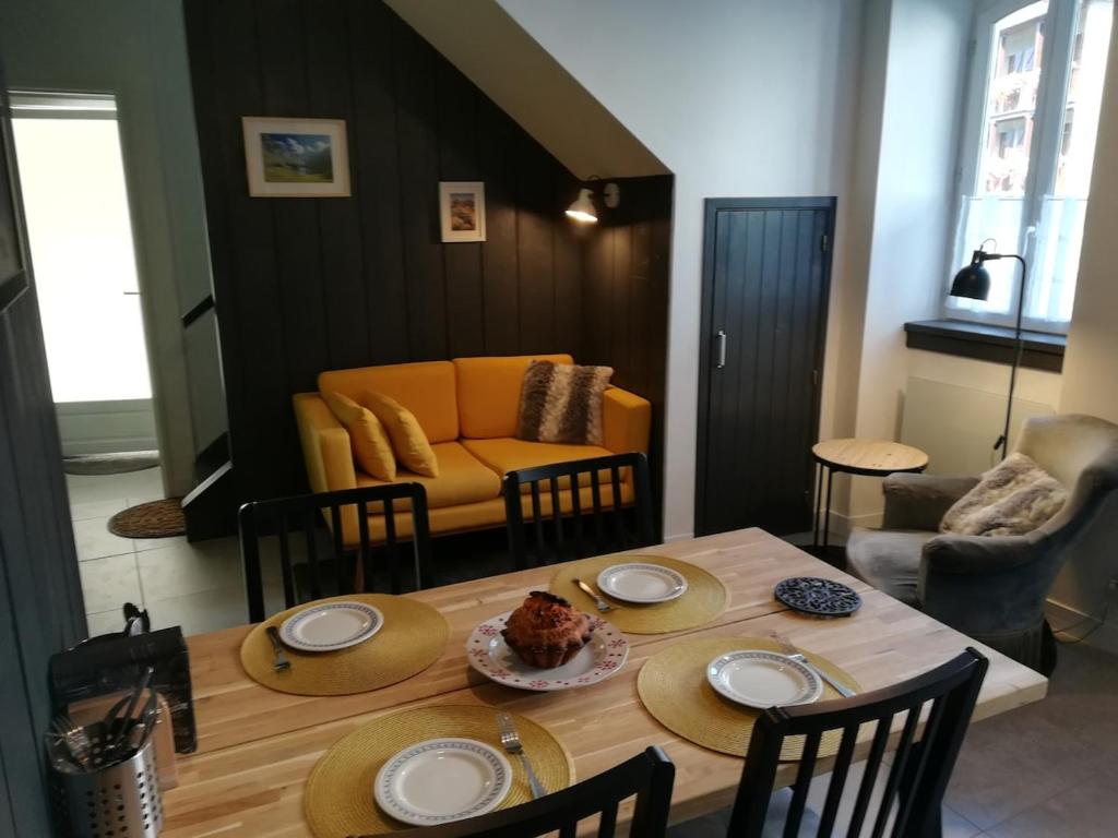 une salle à manger avec une table et un canapé dans l'établissement Maison de village, à Campan