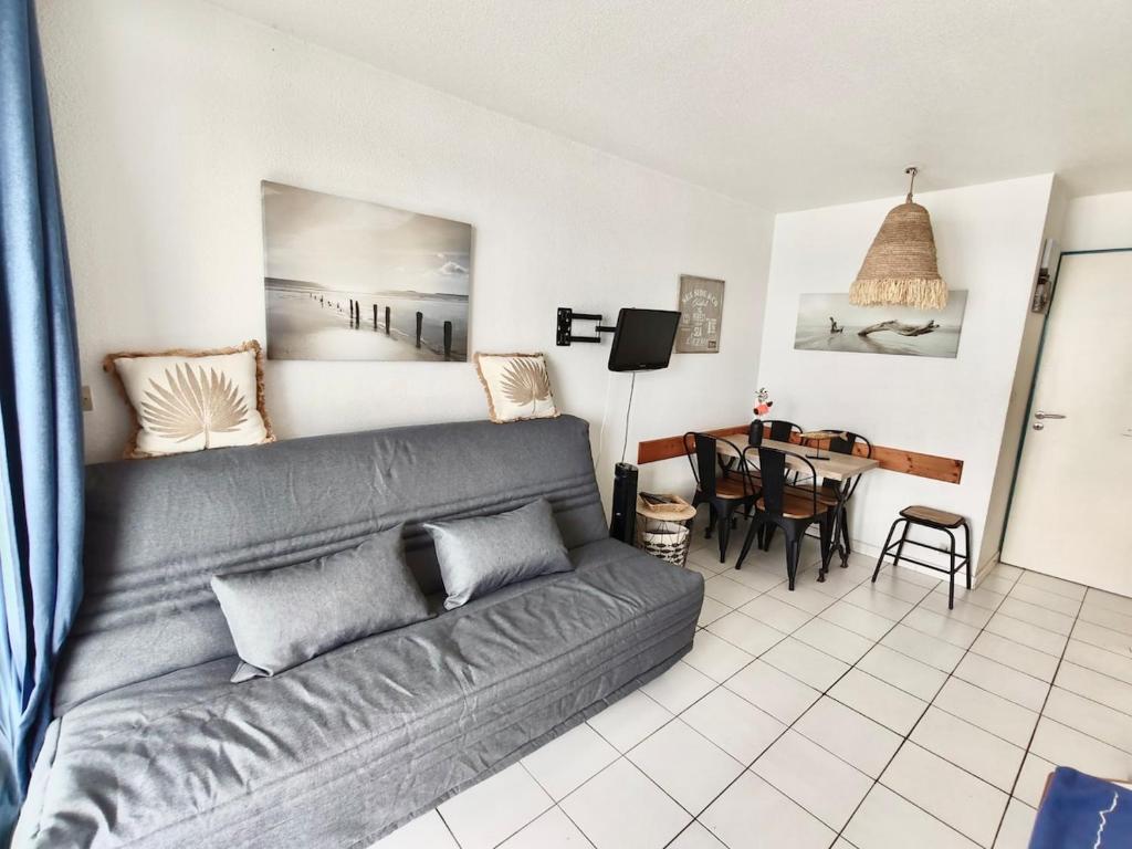un salon avec un canapé et une table dans l'établissement Appartement familial et pratique, au Barcarès