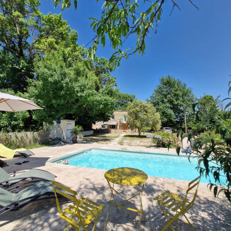une piscine avec deux chaises et une table dans l'établissement Charming converted Mill with Private Swimming Pool, à Forcalqueiret