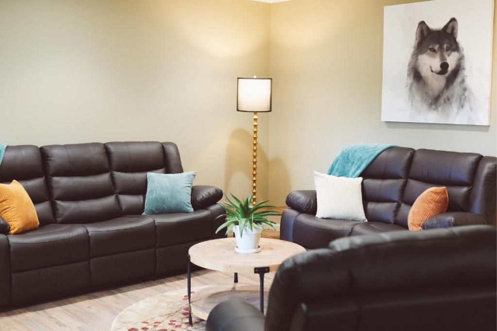 a living room with a black leather couch and a table at Lakeshore Lodging Apartment G in Homer
