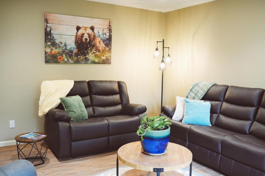 a living room with a brown leather couch and a table at Lakeshore Lodging Apartment F in Homer