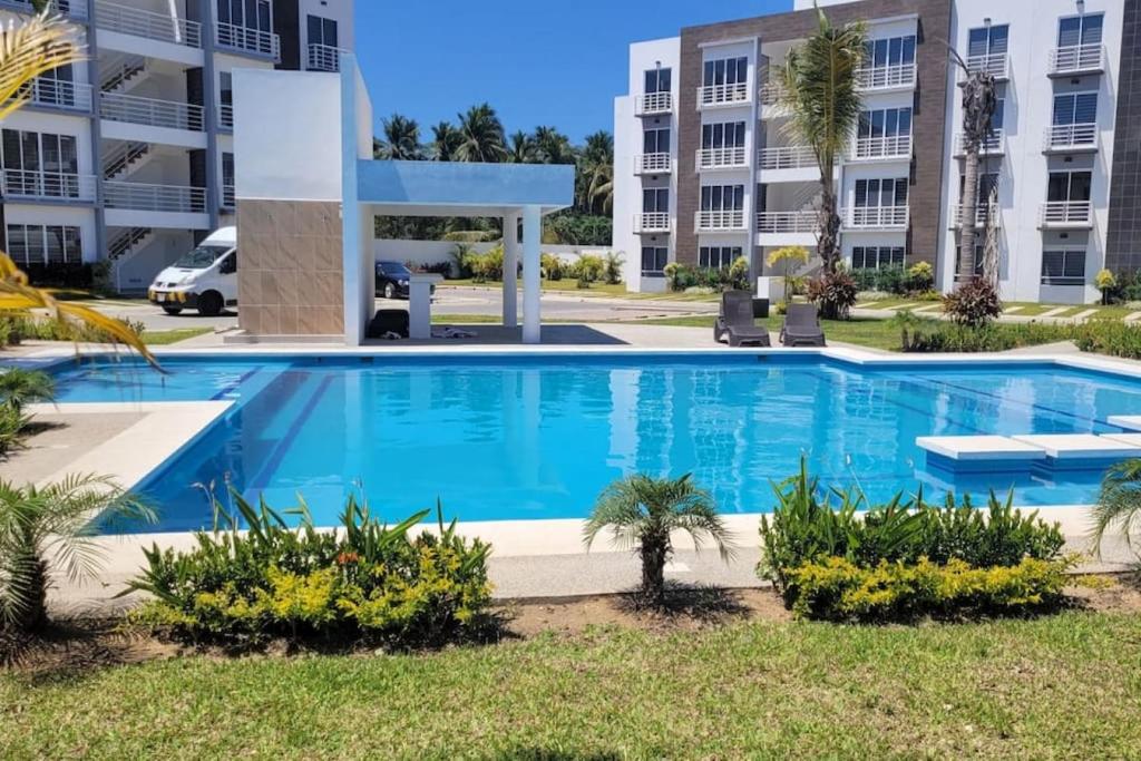 a swimming pool in front of a building at Paktinemi Diamante Fantastic View Beach Club in Acapulco