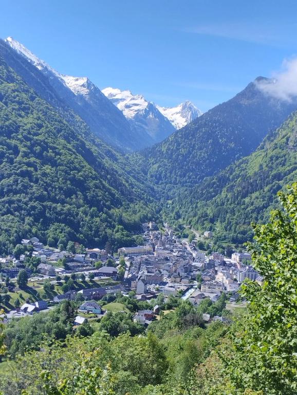 une ville dans une vallée avec des montagnes enneigées dans l'établissement Studio confortable à Cauterets - 40 m² - Vue sur la montagne, à Cauterets