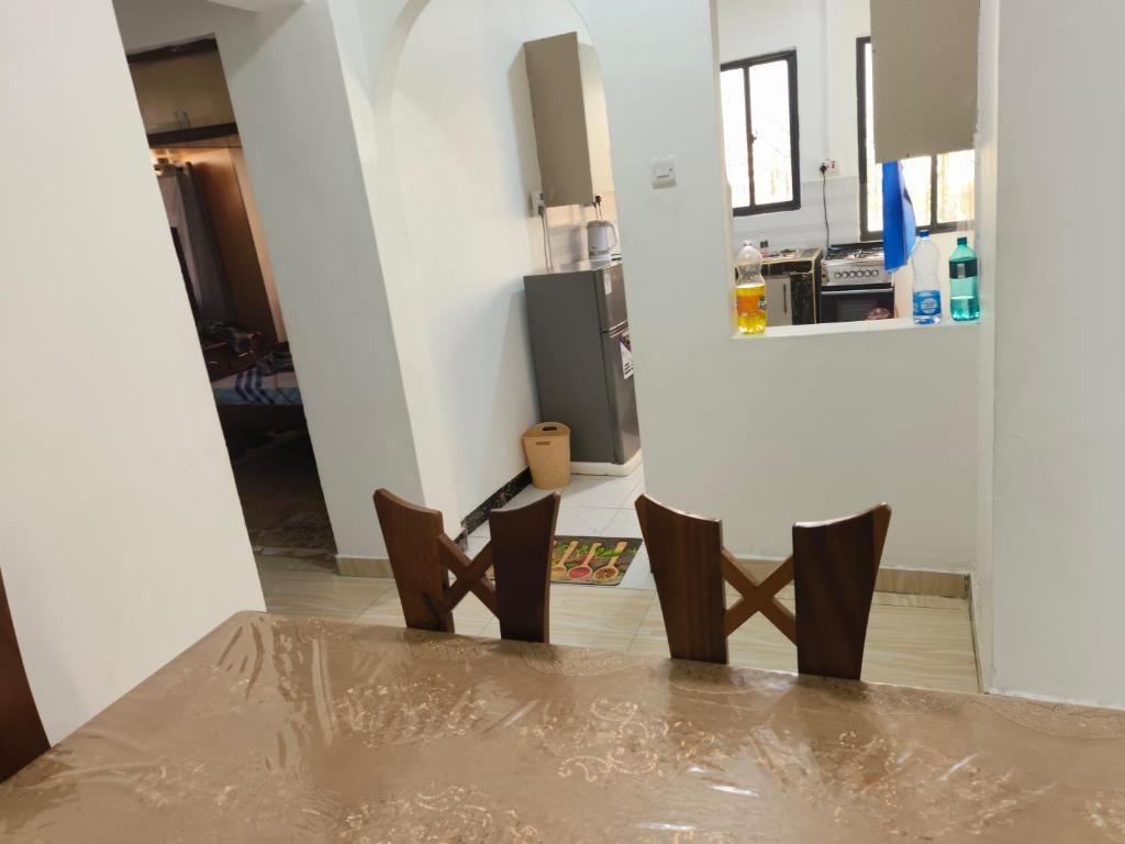 a dining room with a table and two chairs at Mama Abayi Fakhi in Mombasa