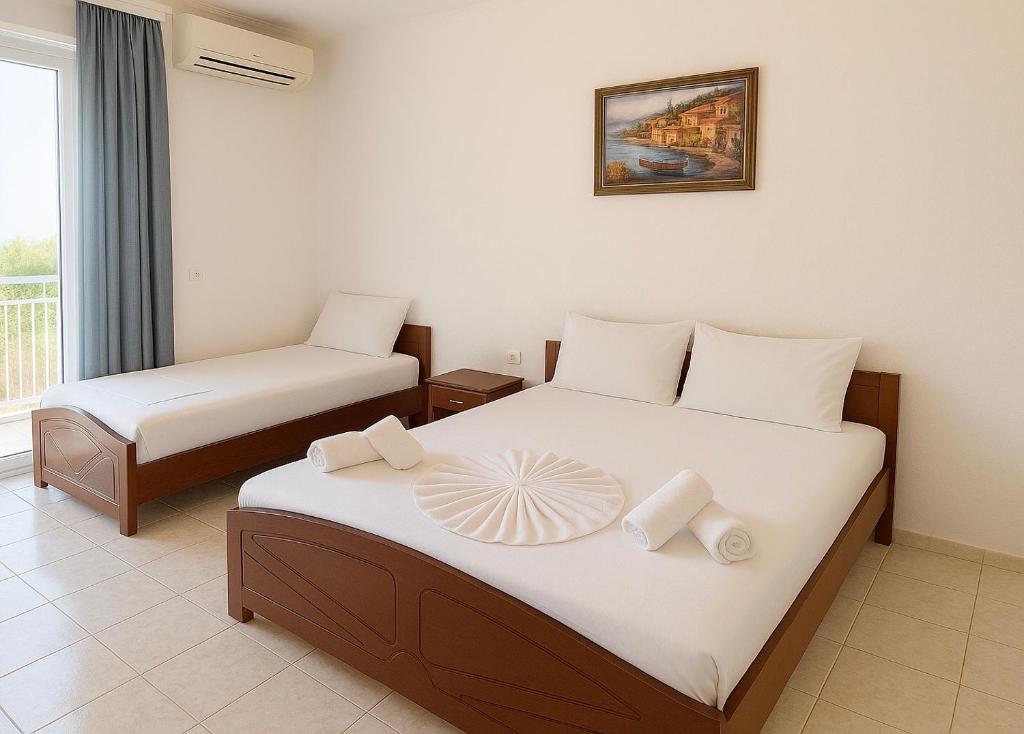 una camera d'albergo con due letti e una finestra di Vila Elite a Ksamil