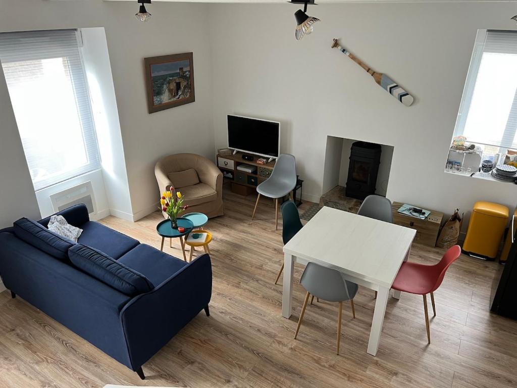 un salon avec un canapé bleu et une table dans l'établissement Charmant Penty proche toutes commodites, au Guilvinec