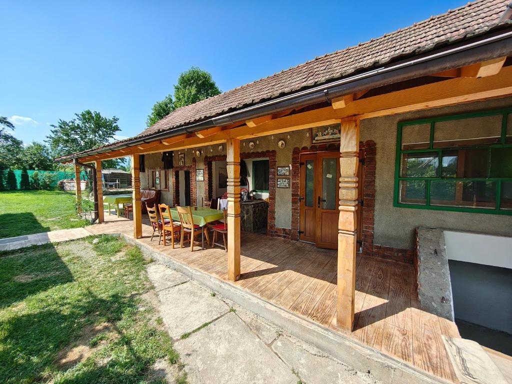 une maison avec une terrasse avec une table et des chaises dans l'établissement La Tataia Zahei, à Drăguş
