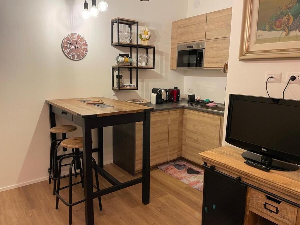a small kitchen with a table and a television at monolocale Emy in Valsassina in Introbio
