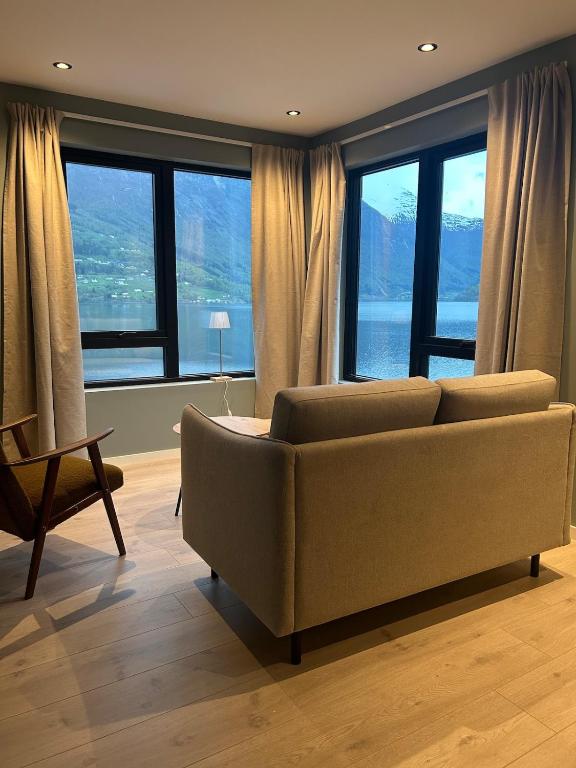 a living room with a couch and large windows at Granli-Apartment in Stryn
