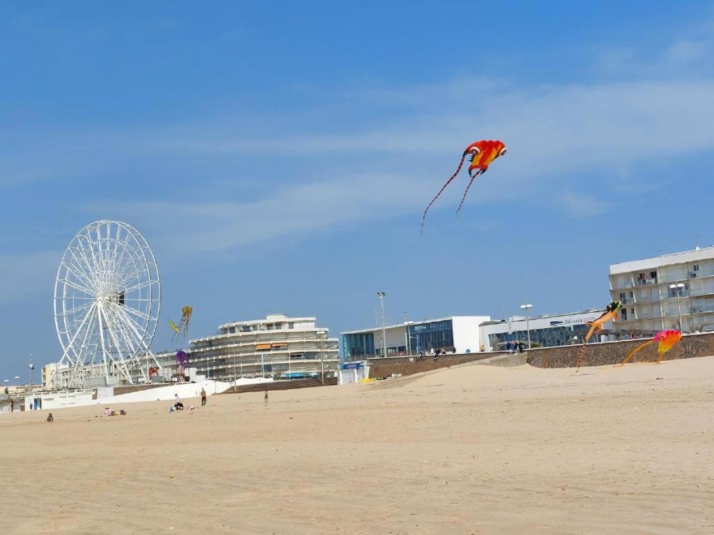 un cerf-volant volant dans le ciel au-dessus d'une plage dans l'établissement Maison bord de plage, à Saint-Hilaire-de-Riez