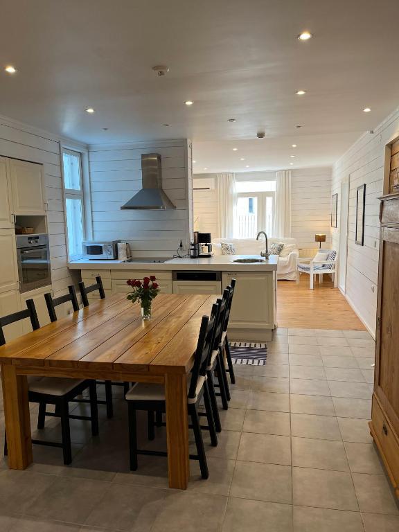 a kitchen and dining room with a wooden table and chairs at Villa Elisabeth Apartments in Pärnu