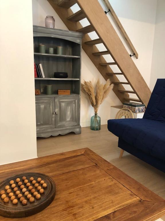 un salon avec un canapé bleu et une table dans l'établissement Grands Jardins Cottage Charming countryside, à Sainte-Geneviève-lès-Gasny