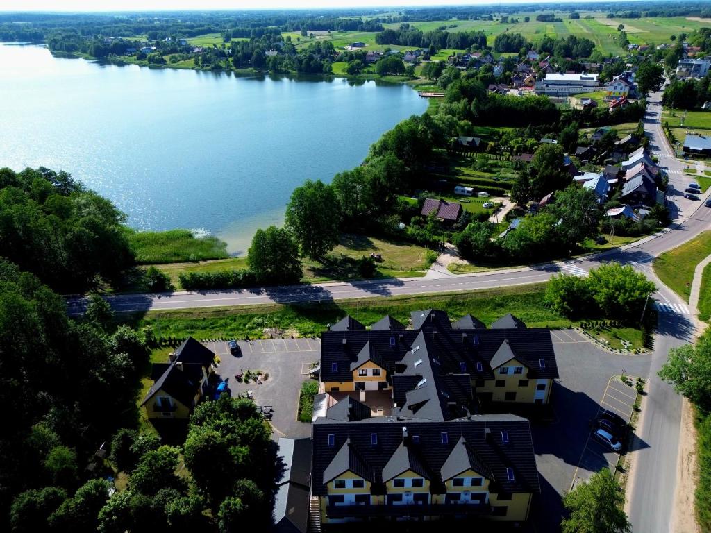 Aerial view of lakeside hotel surrounded by greenery and roads.