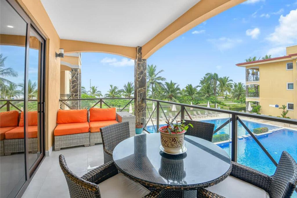 a balcony with a table and chairs and a pool at 2 Bedroom Oceanview Beachfront Condo Jaco Beach in Jacó
