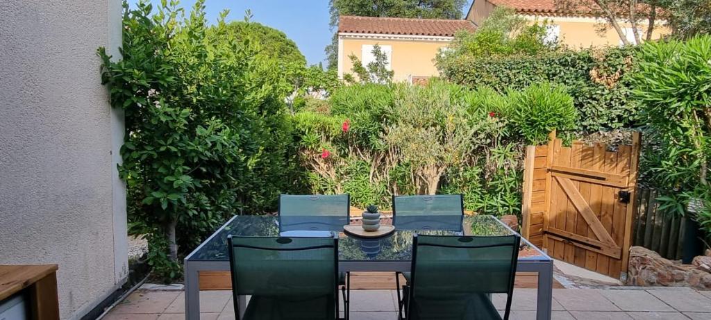 - une table à manger et des chaises dans le jardin dans l'établissement Bastidon l'Arc en ciel, à Fréjus