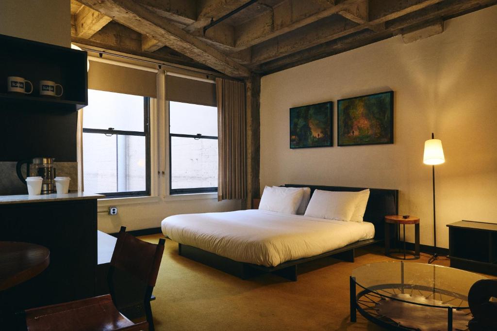 a bedroom with a bed and two windows at STILE Downtown Los Angeles by Kasa in Los Angeles
