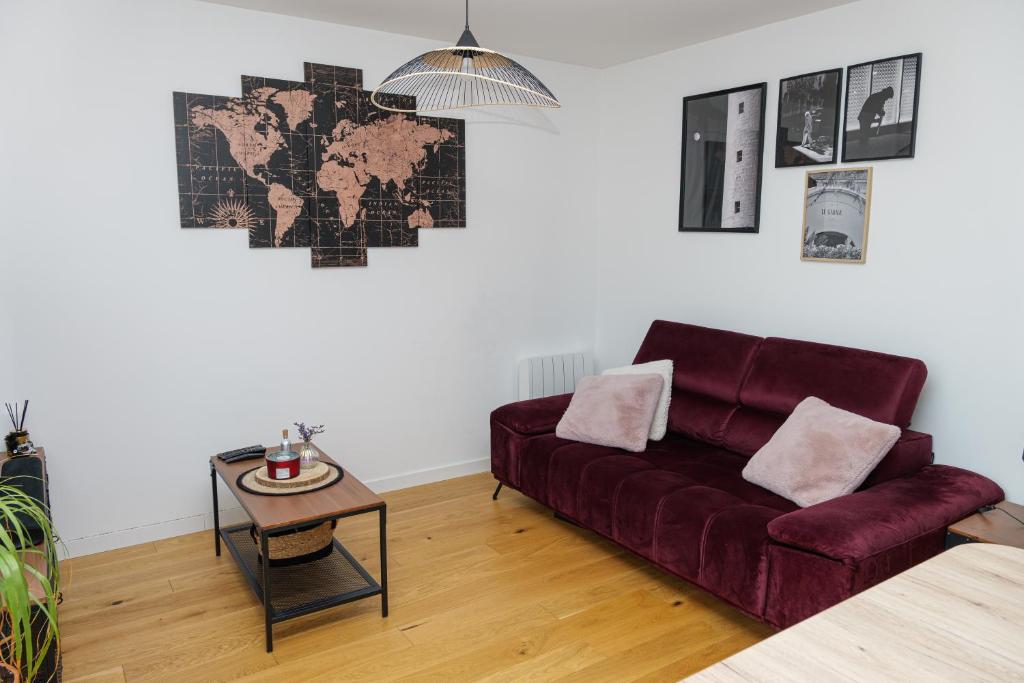 un salon avec un canapé rouge et une table dans l'établissement La Parenthèse Sablaise, à Les Sables-dʼOlonne