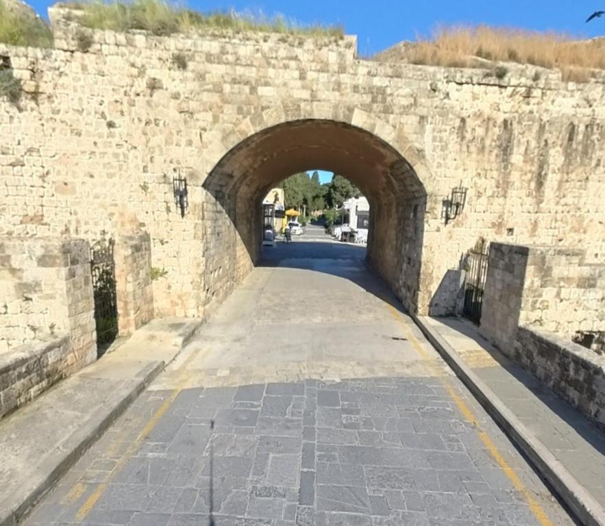 łuk w kamiennej ścianie z drogą w obiekcie Domus Fidias w mieście Rodos