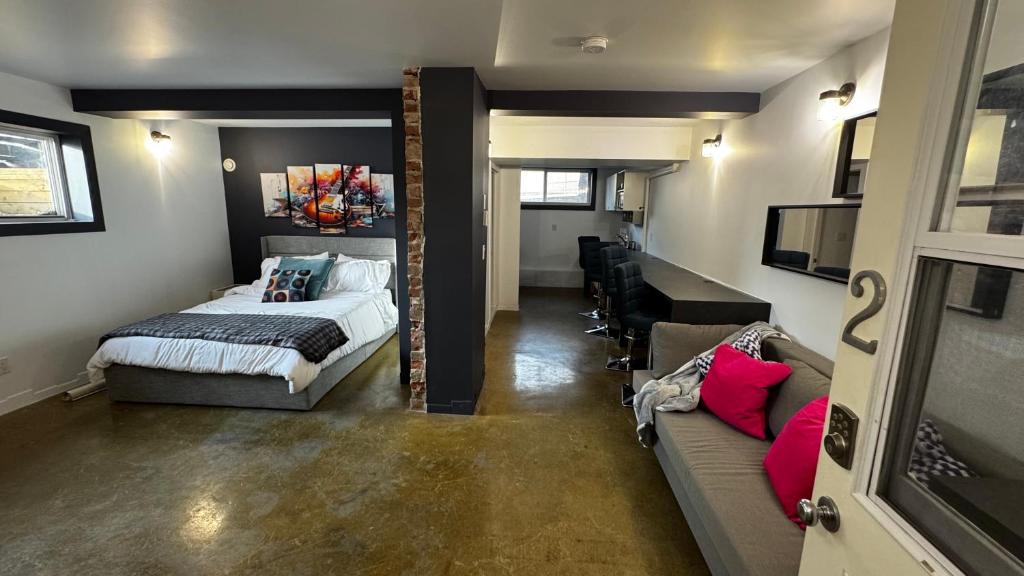 a bedroom with a bed and a couch at Main Street Suites Nanton in Nanton