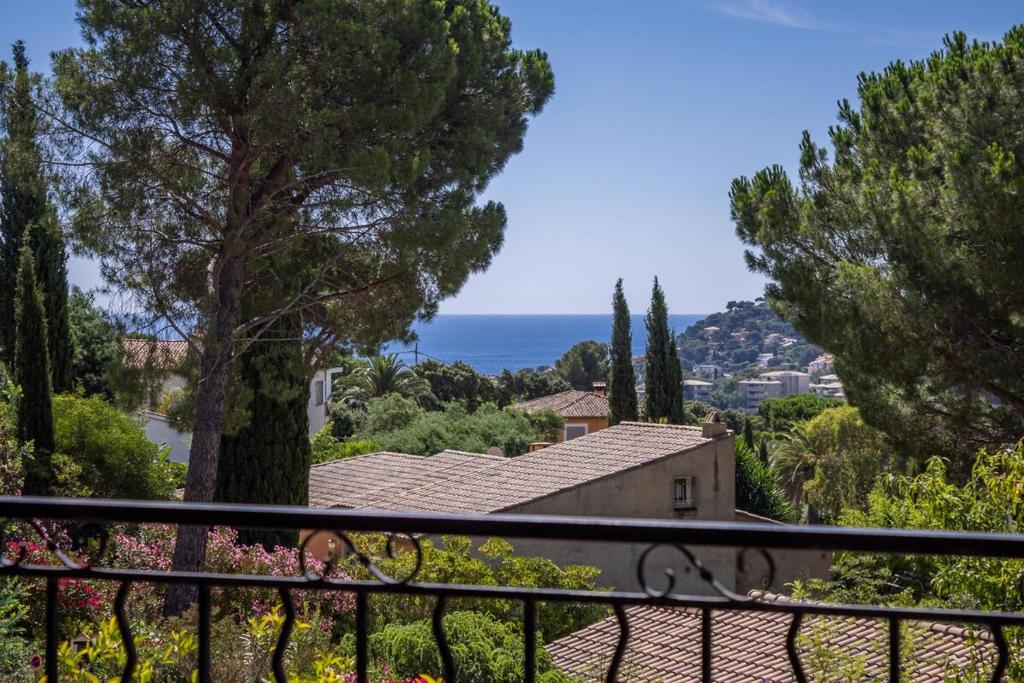 a balcony with a view of a house and the ocean at Villa Aquavit in Cavalaire-sur-Mer