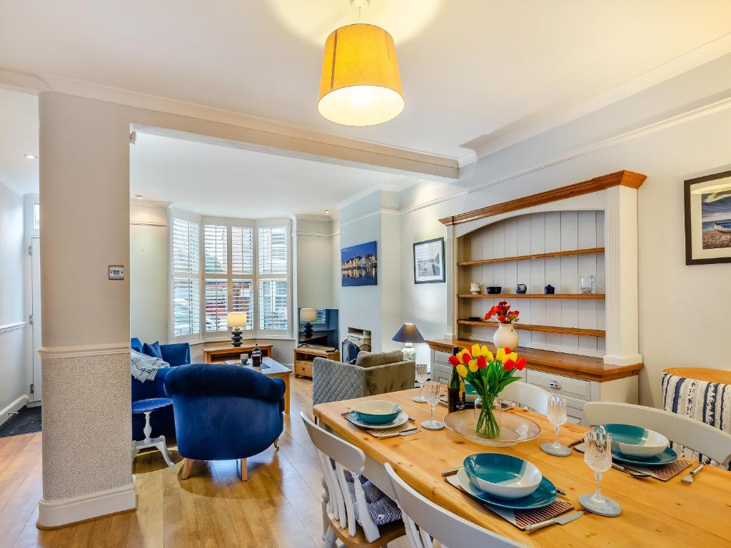 a dining room and living room with a table and chairs at Pebble Cottage in Weymouth