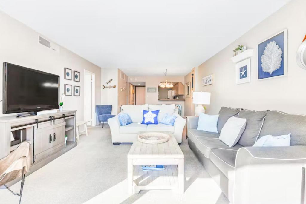 a living room with a couch and a tv at Sea Colony - 206 Brandywine House Rd in Bethany Beach