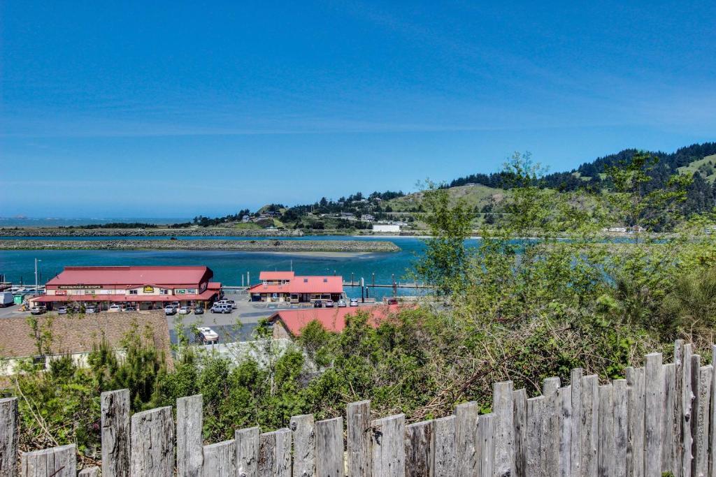 a view of a lake and a restaurant with a fence at Harbor View Cottage A in Gold Beach