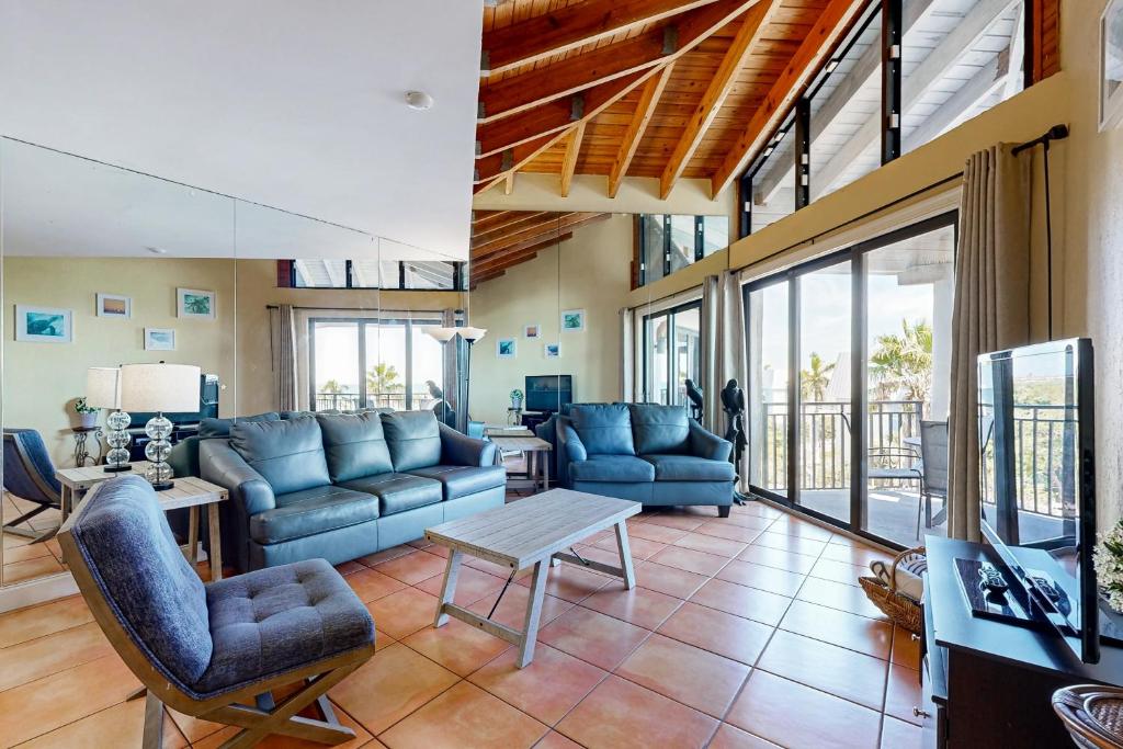 a living room with blue couches and a table at Atlantic Parrot in Key West