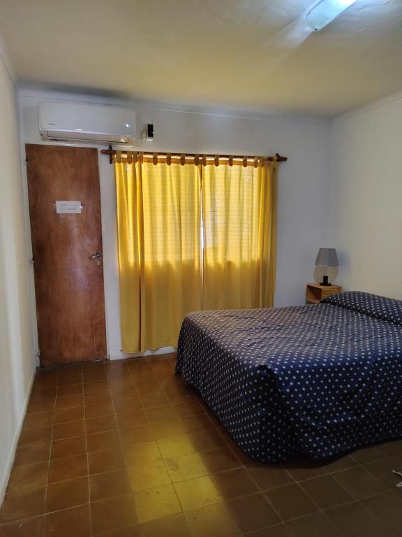 a bedroom with a bed and a yellow curtain at Departamento Plaza España in San Rafael