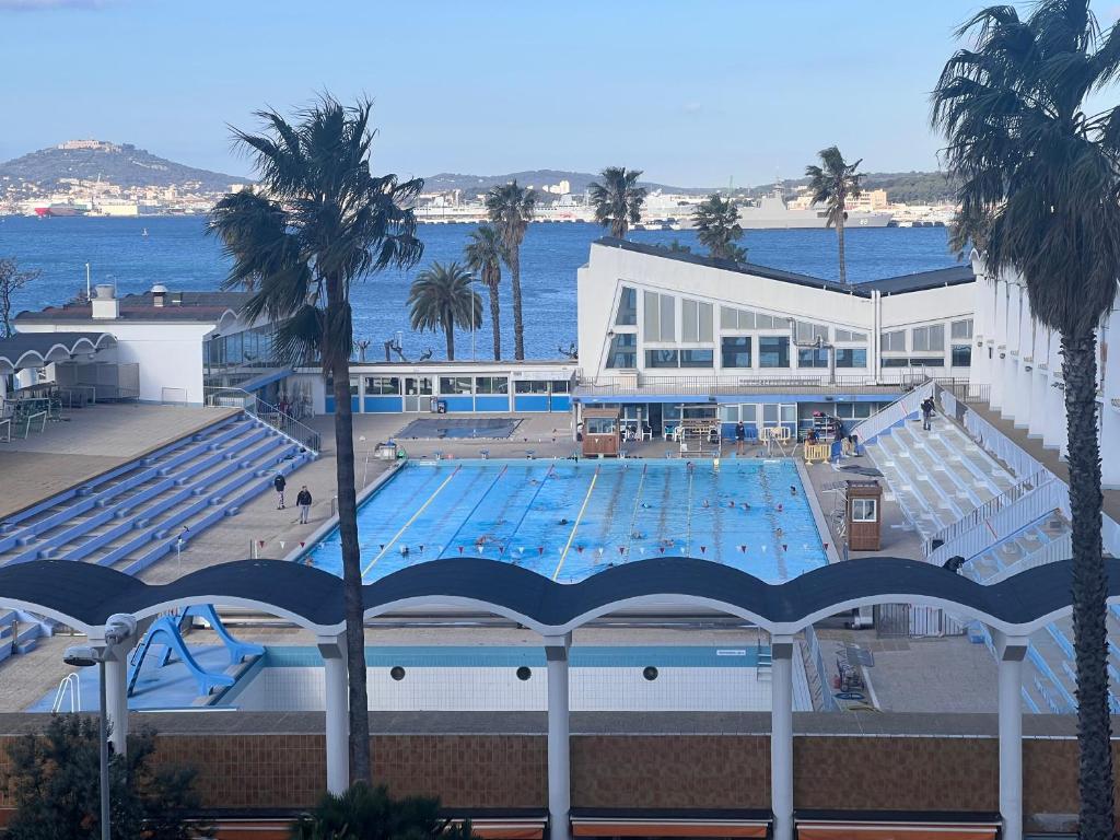 une grande piscine à côté d'un grand bâtiment dans l'établissement La Girelle, à Toulon