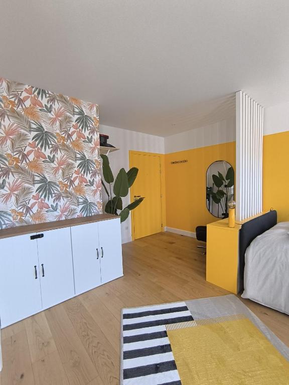 - une chambre avec un lit et un mur jaune dans l'établissement Le Yellow - Moderne & design - Centre Metz - Wi-Fi, à Metz
