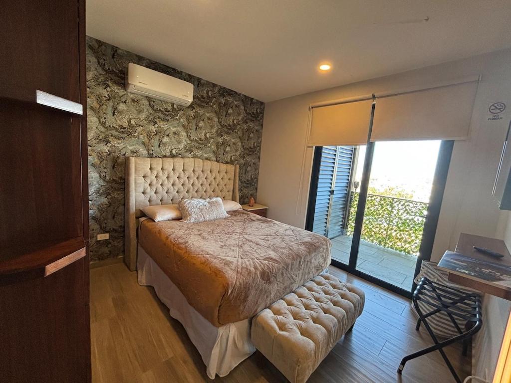 a bedroom with a bed with a stone wall at Apartment with Excellent Ocean View, Terra 194 in Cabo San Lucas