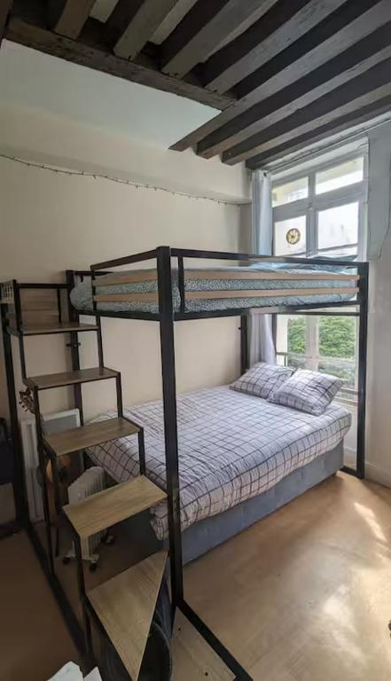 - une chambre avec 2 lits superposés et une chaise dans l'établissement Charmant studio calme et lumineux à Notre-Dame, à Paris