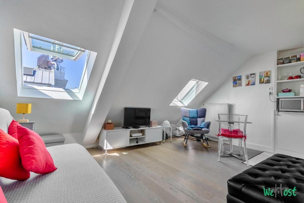 un salon avec un canapé et une fenêtre dans l'établissement Château d'Eau 3 KP- Escapade Parisienne - Lodging for 2 Paris 10, à Paris